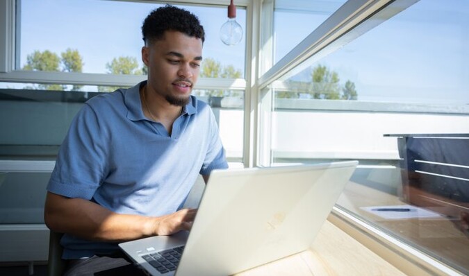 Persoon typend bij het raam